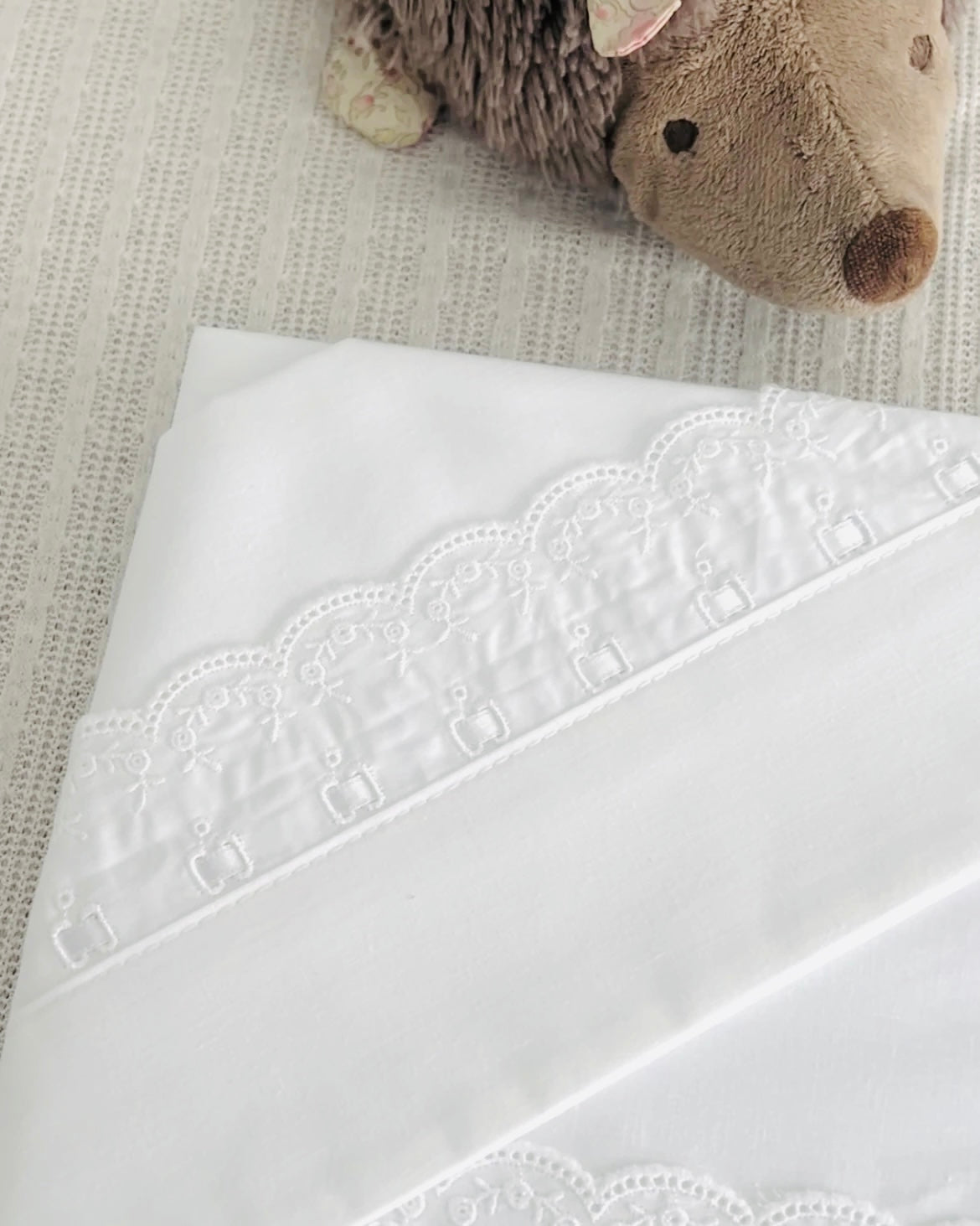 Conjunto de lençóis em algodão para berço, alcofa ou next2me, com renda delicada e fitinha decorativa. Inclui lençol de baixo, lençol de cima e forra de almofada. Um toque clássico e suave, feito em Portugal.
