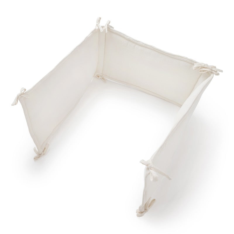 Contorno de berço em algodão de tom creme marfim, perfeito para criar um ambiente sereno, seguro e confortável para o bebé.