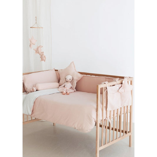 Contorno de berço em algodão de tom rosa nude, perfeito para criar um ambiente sereno, seguro e confortável para o bebé.