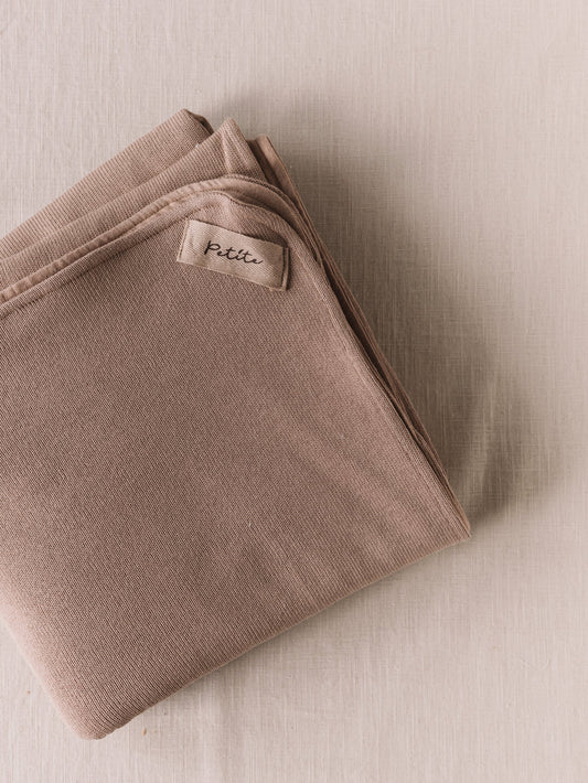 Manta de bebé bege de dupla face, malha macia e musselina de tripla camada, ideal para aconchegar o bebé em casa ou no passeio.