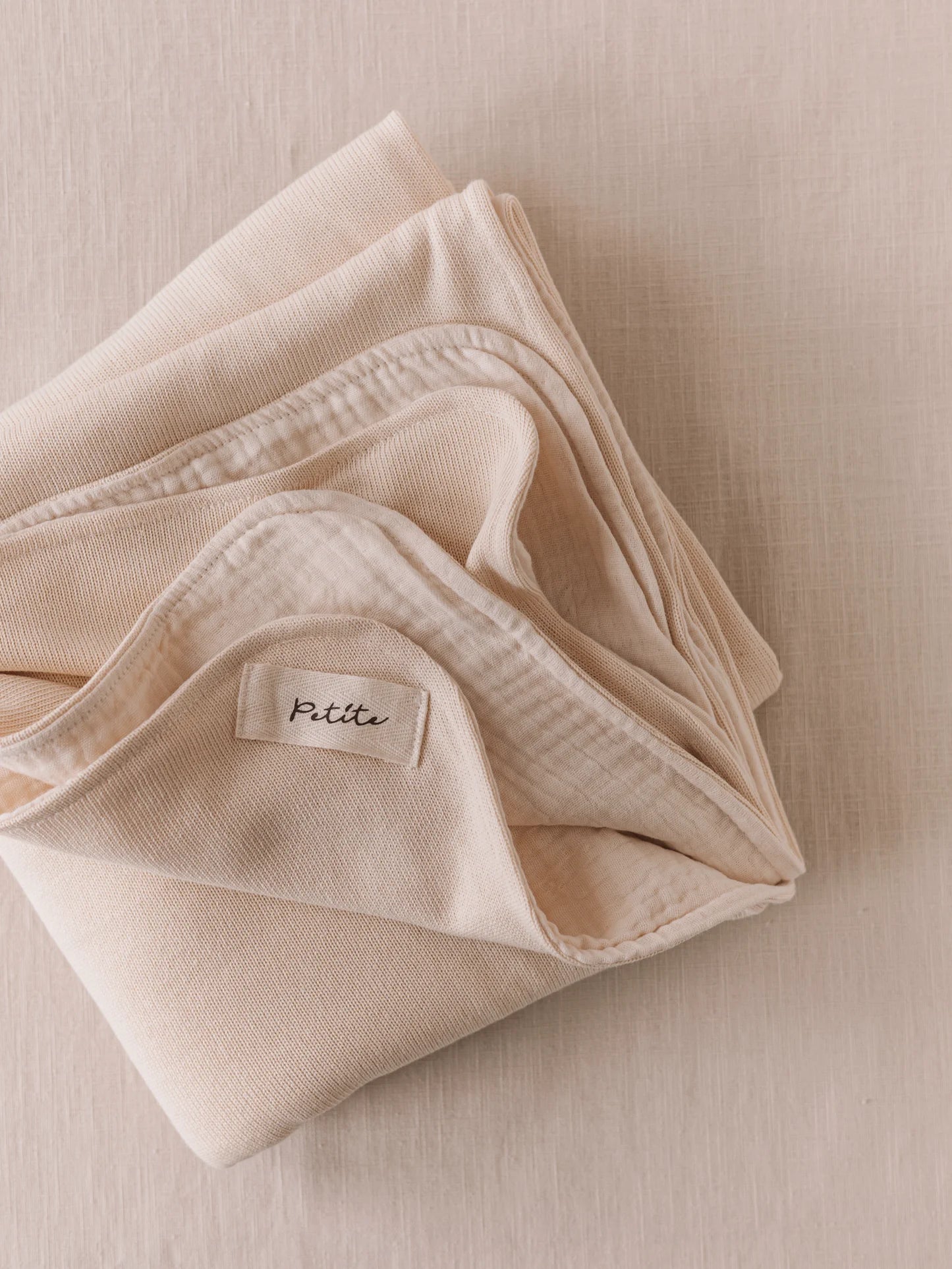 Manta de bebé creme de dupla face, malha macia e musselina de tripla camada, ideal para aconchegar o bebé em casa ou no passeio.