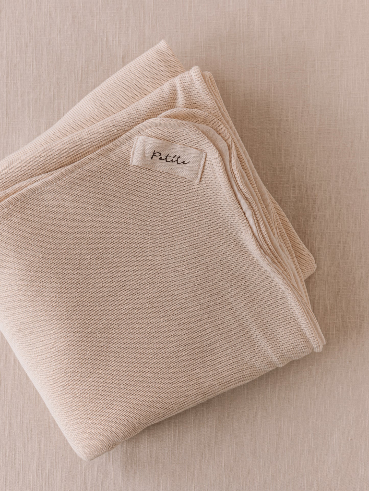 Manta de bebé creme de dupla face, malha macia e musselina de tripla camada, ideal para aconchegar o bebé em casa ou no passeio.