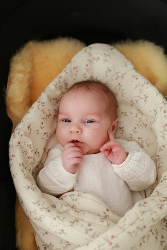 Mantinha envolvente para recém-nascido em formato envelope, ideal para aconchegar o bebé nos primeiros dias, em tecido macio e tom neutro.