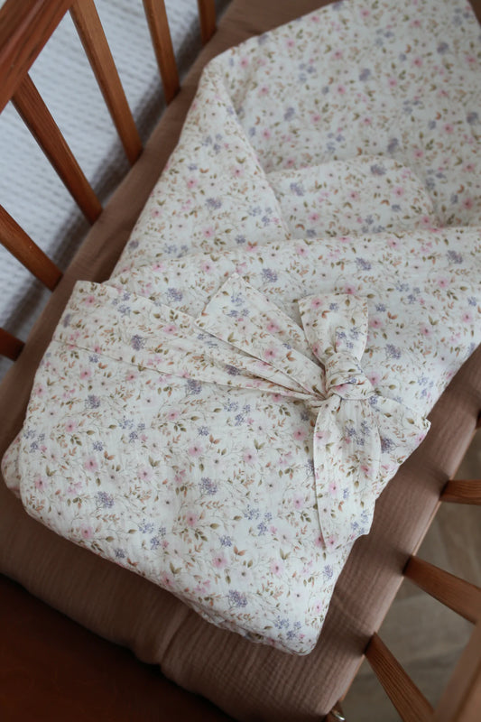 Mantinha envolvente para recém-nascido em formato envelope, ideal para aconchegar o bebé nos primeiros dias, em tecido macio com motivo floral.