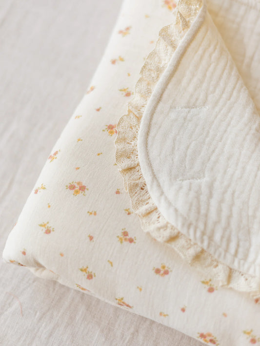 Manta de bebé com motivo floral de dupla face em musselina de tripla camada, com rendinha, ideal para aconchegar o bebé em casa ou no passeio.
