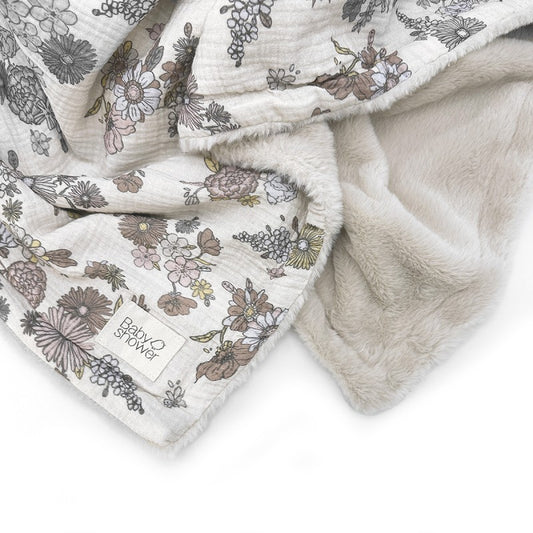 Manta de bebé dupla face, com um lado fofinho e outro em musselina estampada com padrão floral, perfeita para aconchegar o bebé com suavidade e charme.