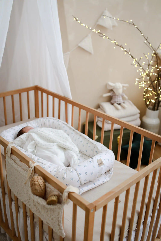 Ninho de bebé redutor de berço em algodão branco com baguinhas azuis, ajustável e com materiais certificados