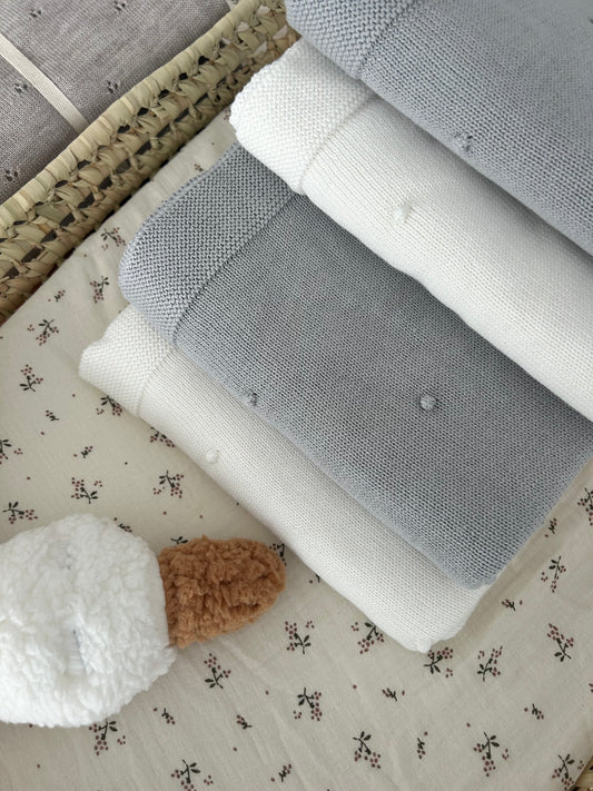 Baby blanket in knitted cotton pompoms
