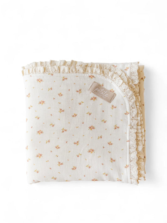 Manta de bebé com motivo floral de dupla face em musselina de tripla camada, com rendinha, ideal para aconchegar o bebé em casa ou no passeio.